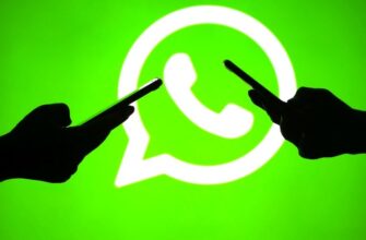 Смартфоны в руках на фоне логотипа WhatsApp