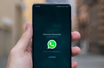 Смартфон в руке с логотипом WhatsApp на экране